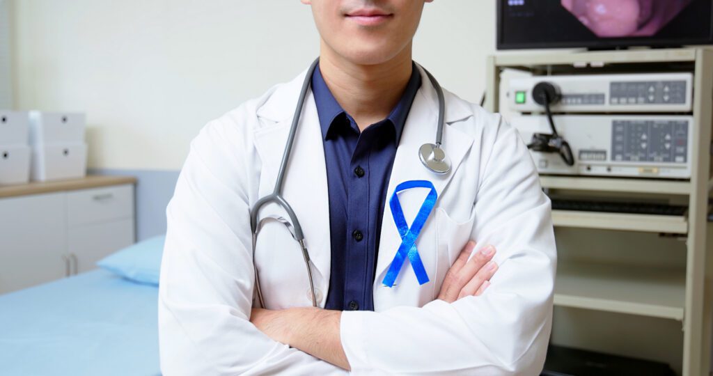 gastroenterologist in clinic wearing blue ribbon for colon cancer awareness month